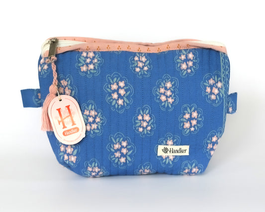 Blue floral-patterned pouch with a visible brand logo on a white background