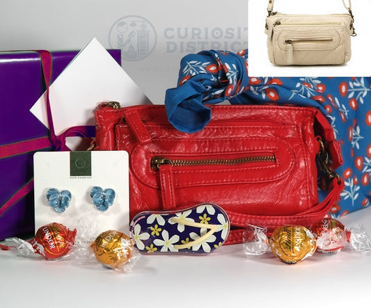 Red handbag with accessories and candies on a white surface