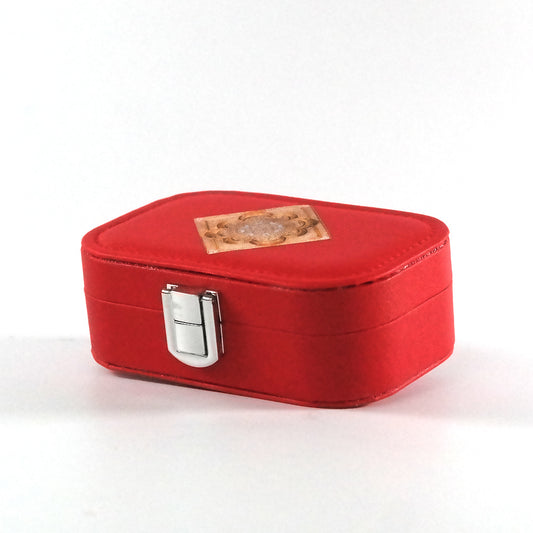 Miniature red jewelry box with a button closure and an Islamic geometric mandala on the tray, pictured from the side.