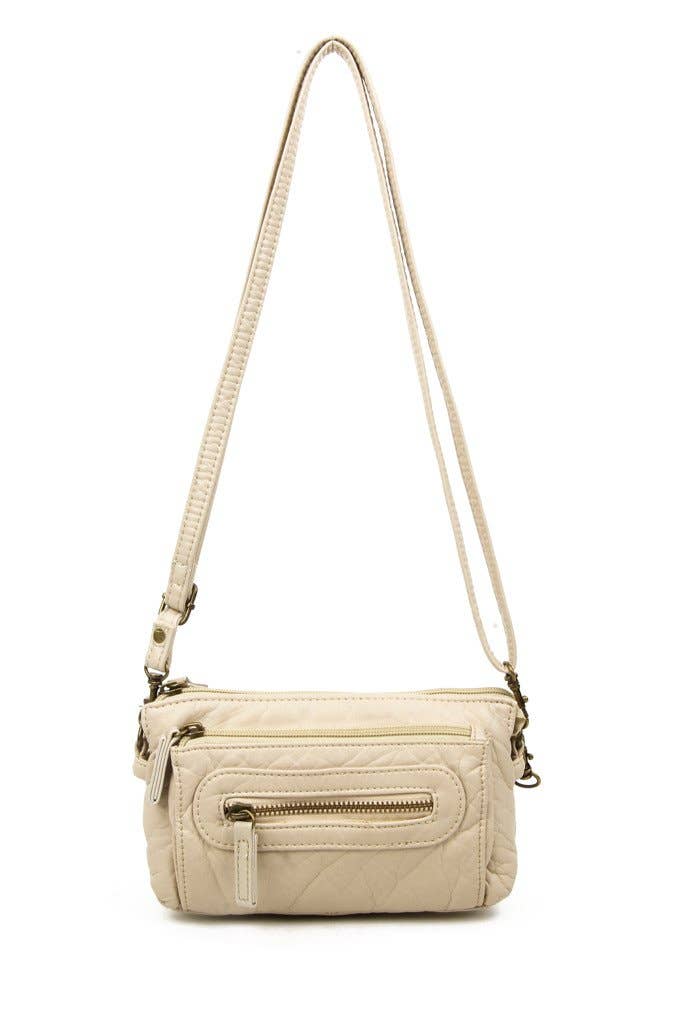Almond crossbody bag with a strap on a white background