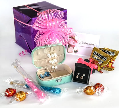 Jewelry set in a box with candies and a Haribo bag on a white background