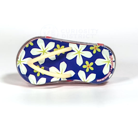 Floral-patterned flip-flop sandal on a white background with 'Curiosity District' branding.