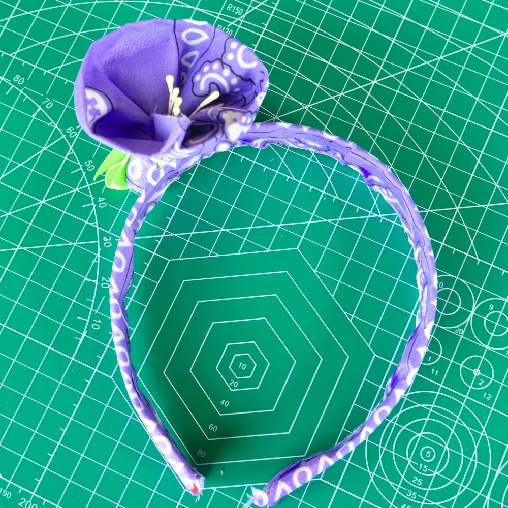 Bandana flower headband against a green crafting background. 