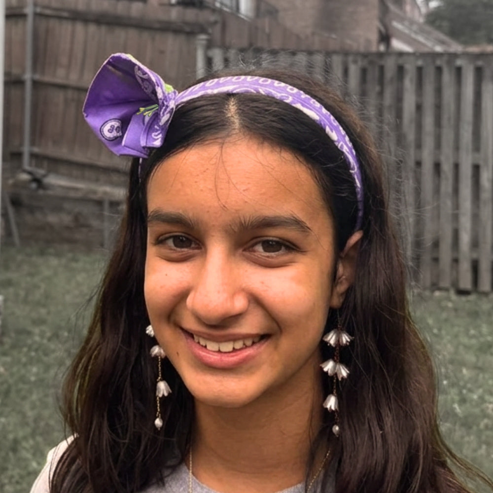 Portrait of a girl wearing the bandana flower headband from the front. 