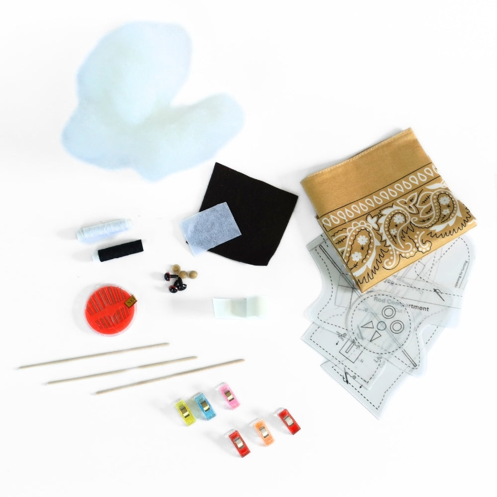 Bandana Flying Bat DIY kit materials including tan bandana fabric, stuffing, felt, interfacing, patterns, wooden rods, thread, needle, clips, eyes, and nose.