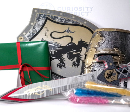 Decorative items including a green box with red ribbon, a metallic sword, and a card with a lion emblem on a white background.
