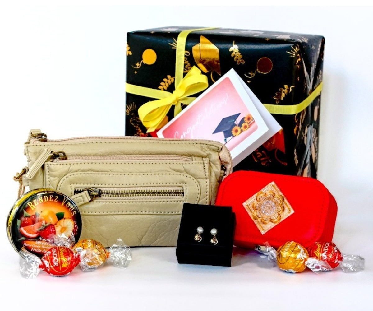 Beige handbag, black graduation box with yellow ribbon, red keepsake box, earrings and decorative candies on a white background