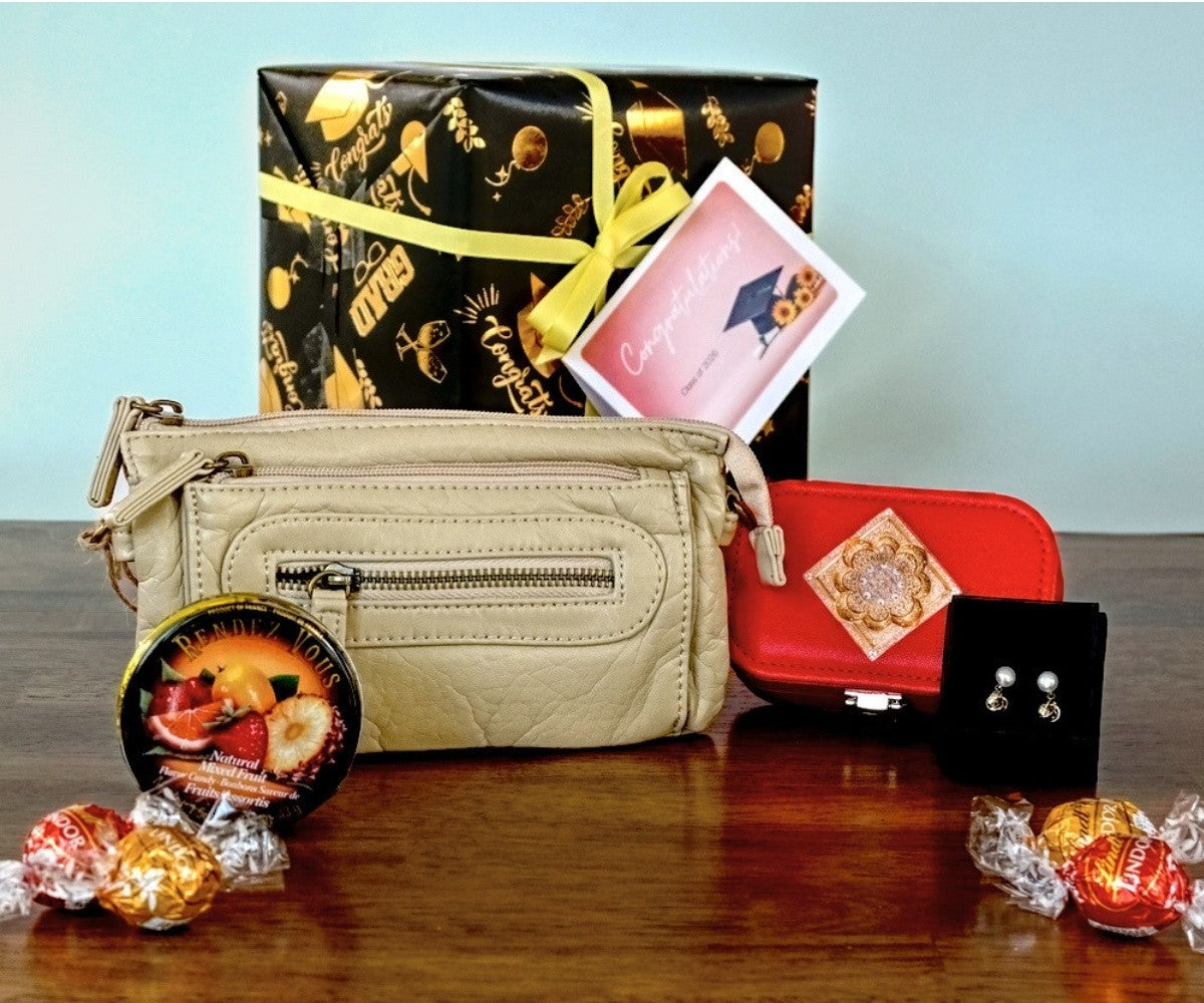 Almond handbag with a keepsake box, gift box, card, and jewelry on a wooden surface.