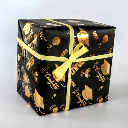 Black gift box with gold patterns and a yellow ribbon on a white background