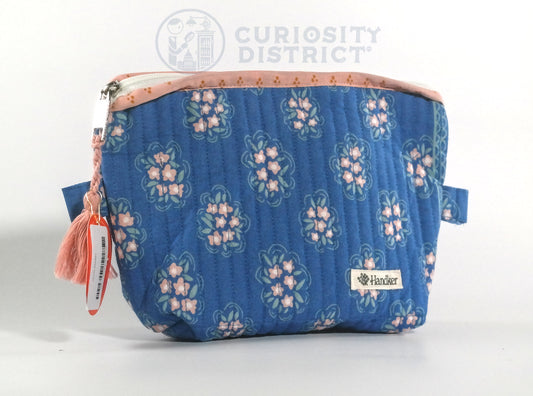 Blue floral-patterned pouch with a visible brand logo on a white background