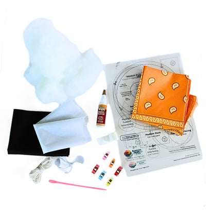 Bandana Pumpkin Trio DIY kit contents with orange bandana, stuffing, patterns, glue, felt, cord, clips, and tools