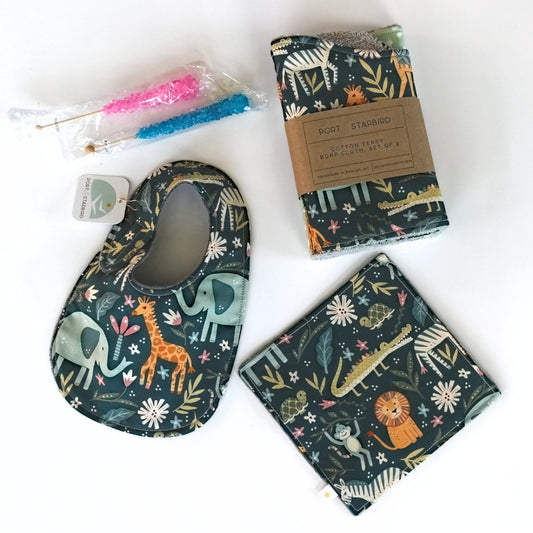 Baby bib, burp cloths, rock candies, and crinkle toy with animal jungle patterns on a white background