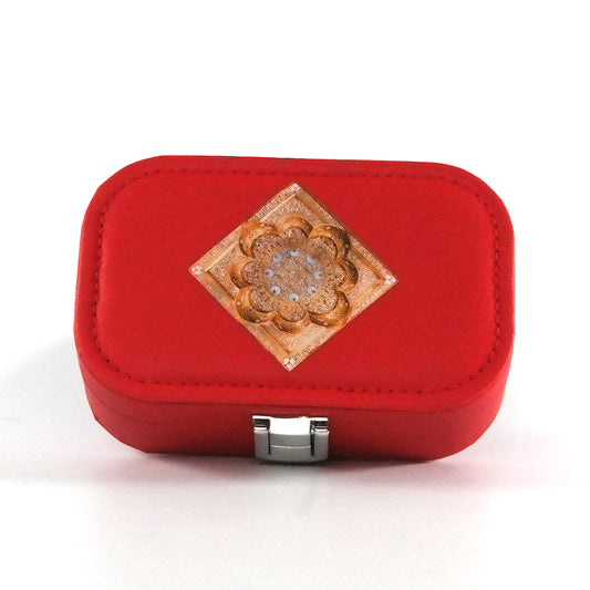 Miniature red jewelry box with a button closure and an  Islamic geometric mandala on the tray, pictured from the top. 