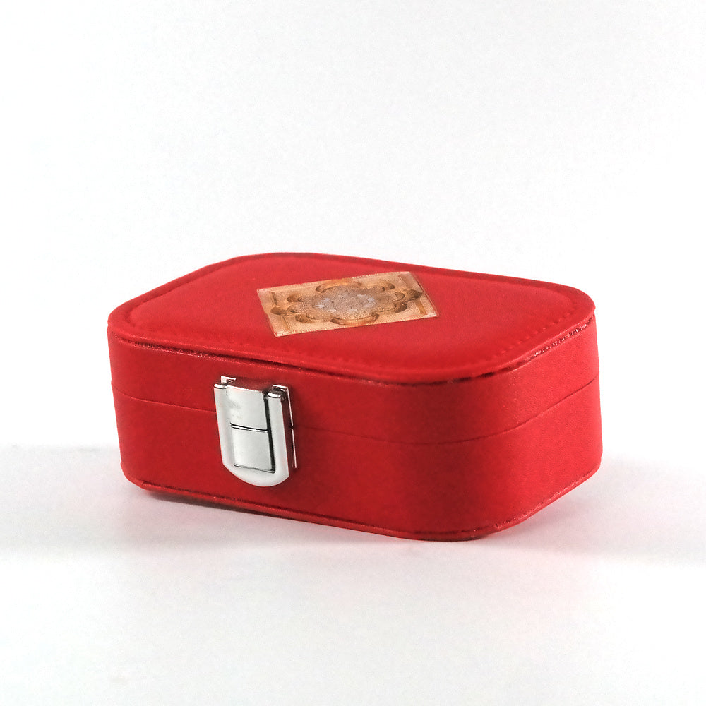 Miniature red jewelry box with a button closure and an  Islamic geometric mandala on the tray, pictured from the side. 