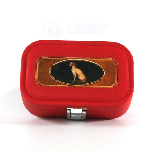 Miniature red jewelry box with a button closure and the portrait of a whippet, pictured from the top. 