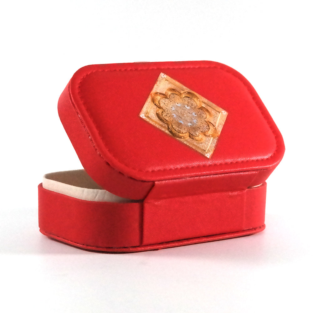Miniature red jewelry box with a button closure and an  Islamic geometric mandala on the tray, pictured from the back. 